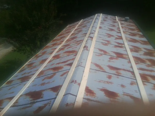 Rusted metal roof panels with new wood purlins before replacement — Storm Damage Roof Repair in Cheswold by Roofing Brothers