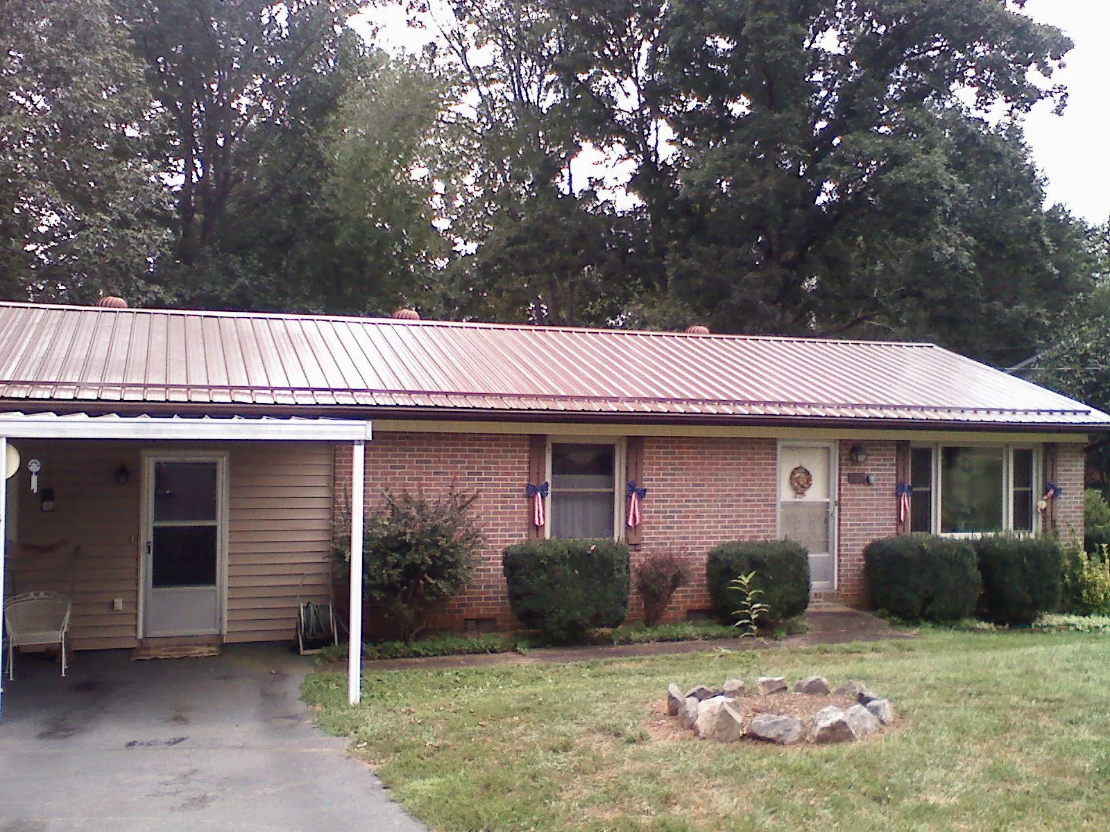Bronze metal roof and carport on a brick ranch home — Roof Repair work by our crew in Cheswold